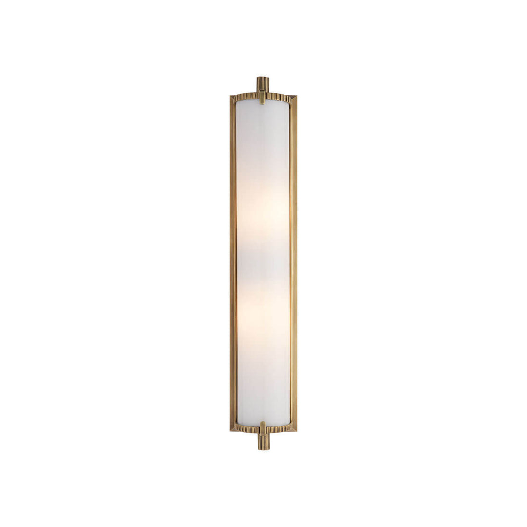 The Calliope Wall Sconce is a long, slim light with an antique brass finish and a white glass lamp shade.