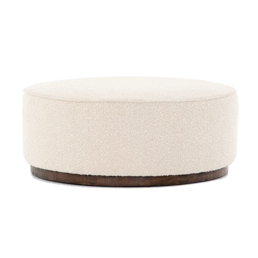 Large round upholstered white ottoman. Ottoman to be paired with a sectional in a living room.