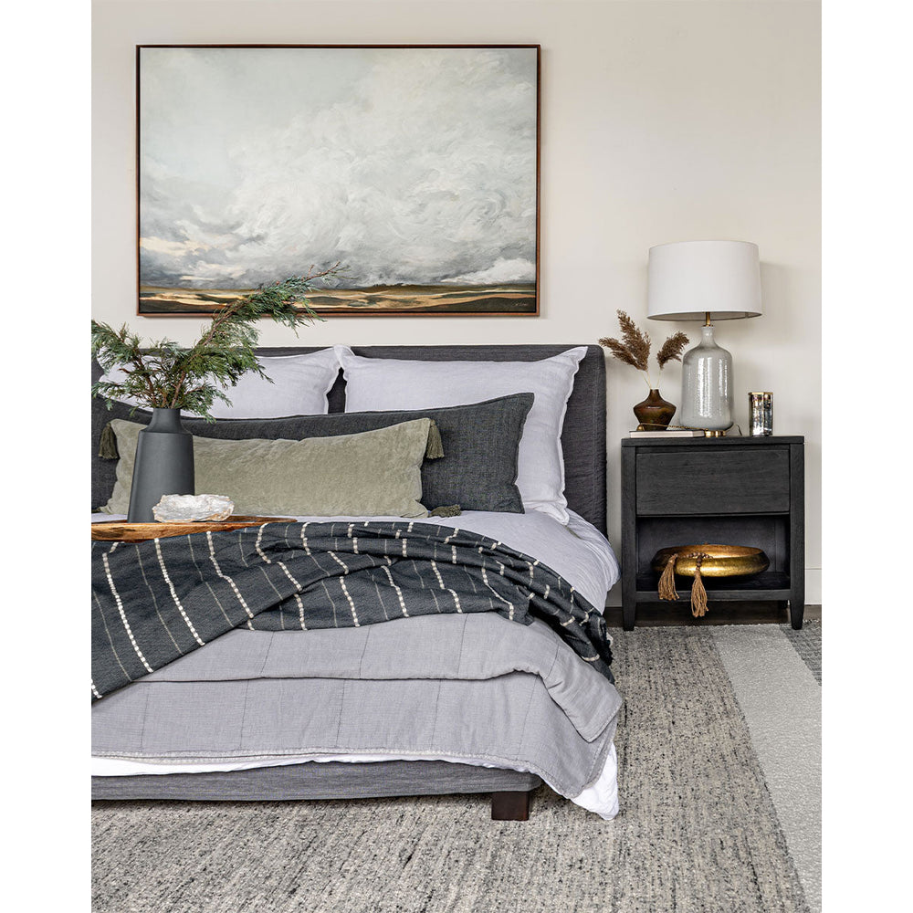 A soft, cool coloured palette in a master bedroom featuring large art and textural bedding.