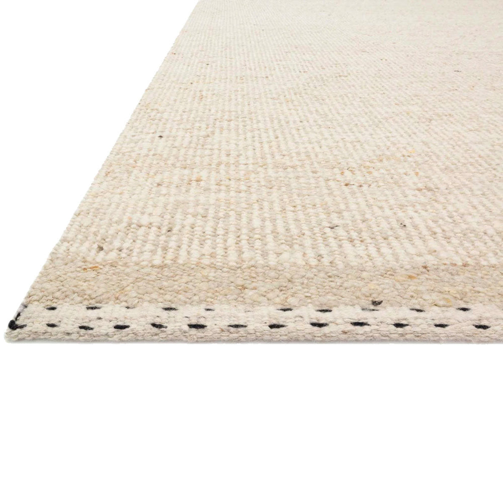 Close up edge detail of the Sauble Beach Oatmeal coloured rug. Made with a blend of wool, cotton, and polyester.