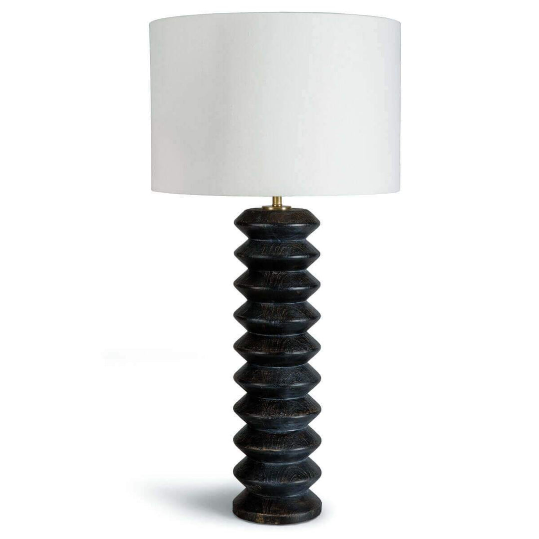 The Piha Table Lamp in a ebony wood finish with carved wood details.