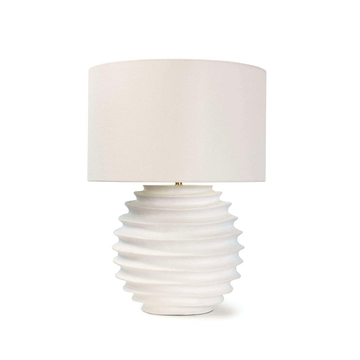 White table lamp with linen shade and accordion-like fluting on round base. 