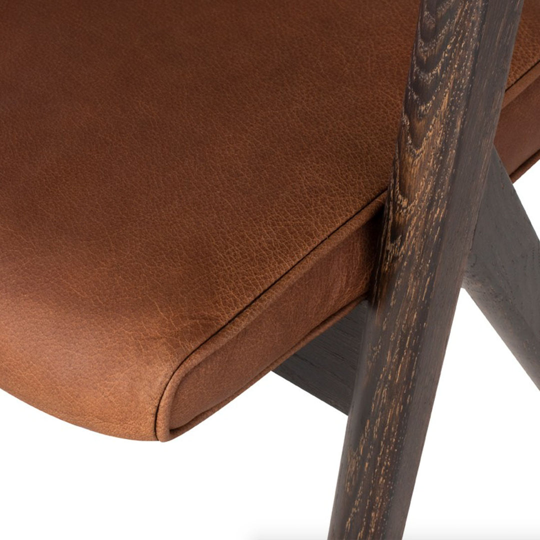 Close up of the textural cognac leather seat and the rich seared oak with a natural tone.
