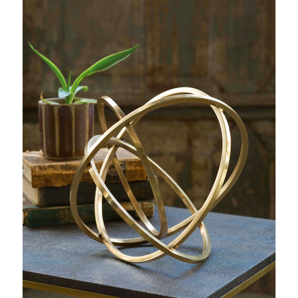 Table with books, plant, and brass eclipse table top accessory.