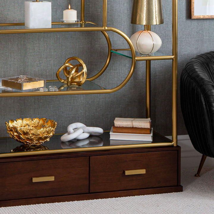 Lifestyle image of gold and wood shelf unit with decorative accesories.