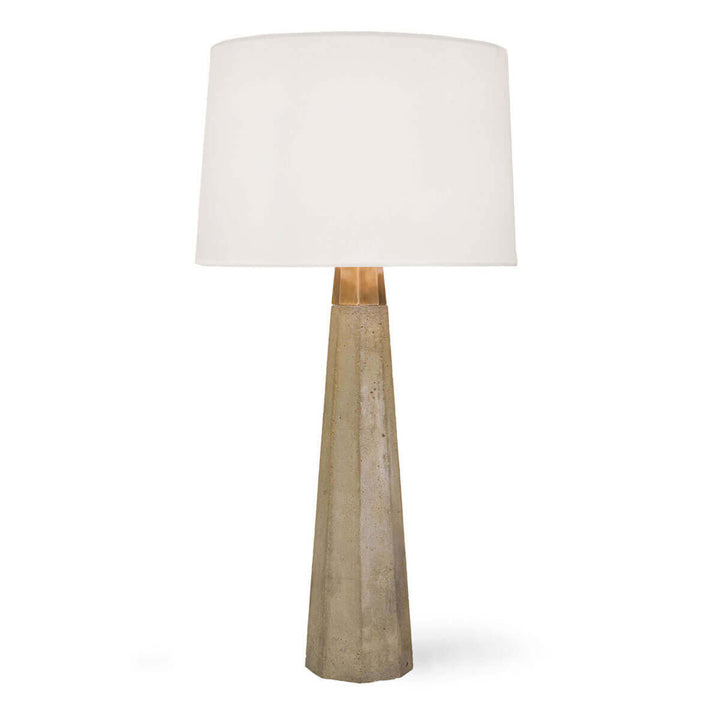 The Rochdale Table Lamp with a tapered concrete base, brass details and a linen lamp shade.