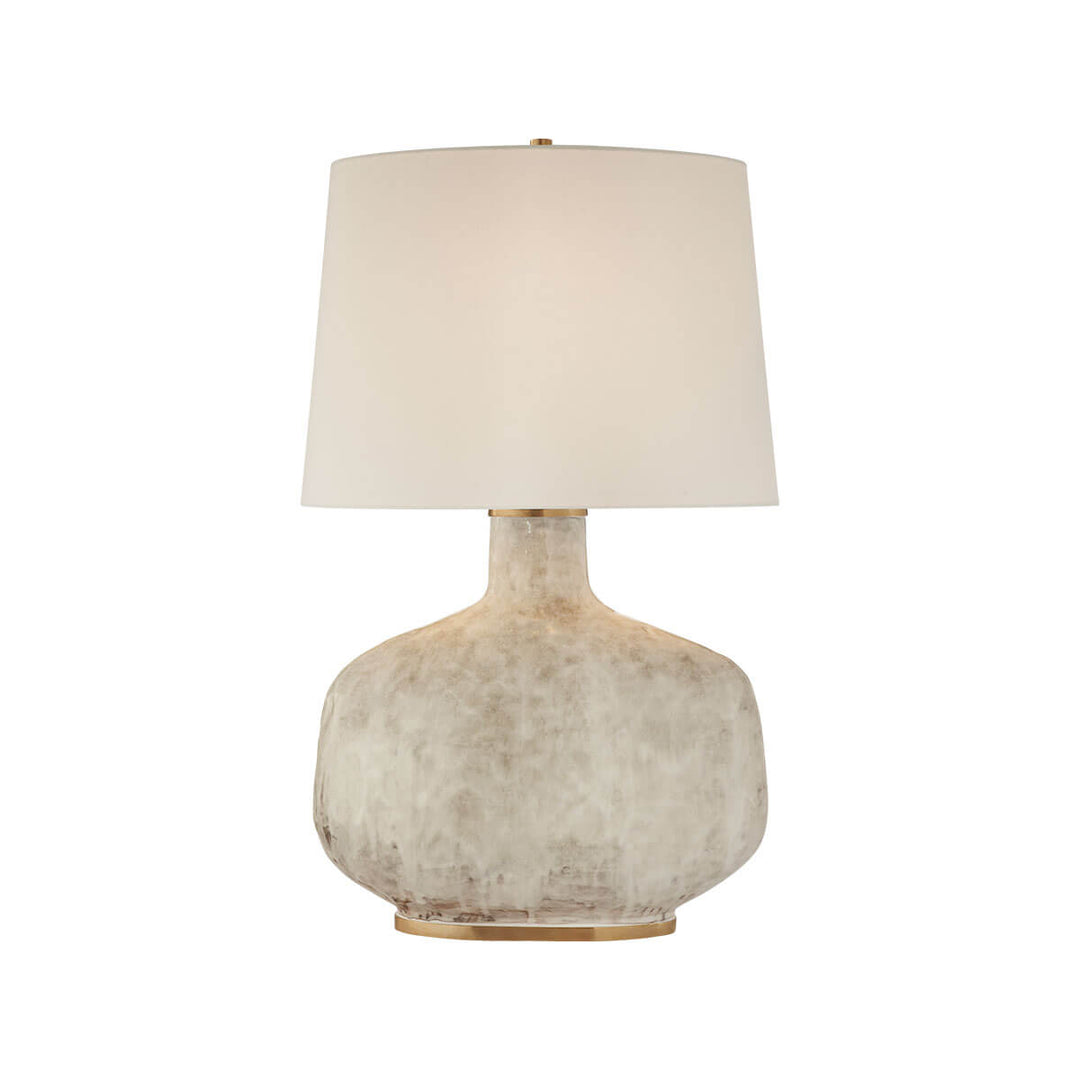 Beton Table Lamp has an antiqued white ceramic sculptural base with a neutral linen shade.
