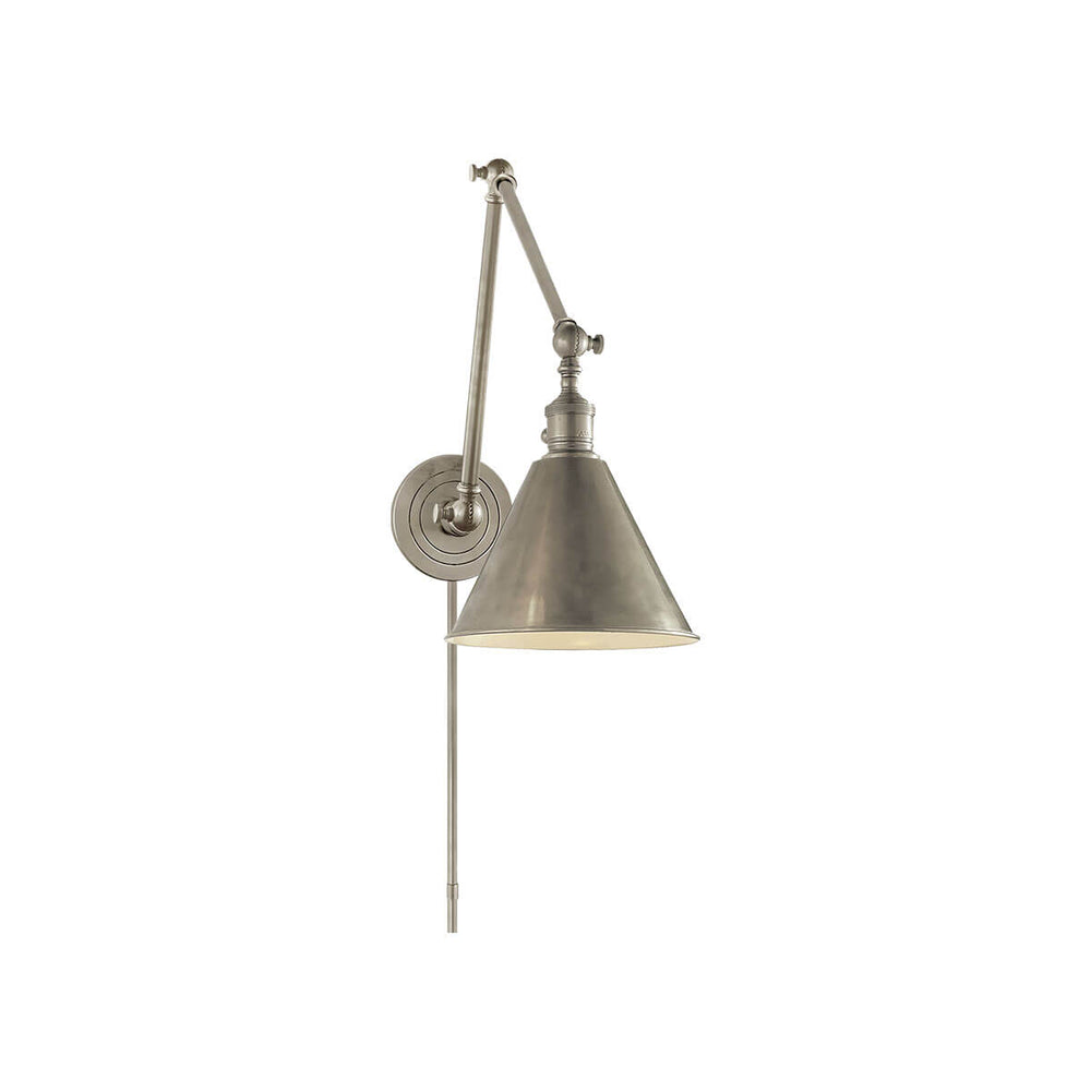 The Boston Double Arm Wall Light is an adjustable wall sconce with a round backplate in an antique nickel finish.