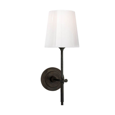 The Bryant Wall Sconce is a traditional sconce with a round backplate and simple arm with a bronze finish and a white glass shade.