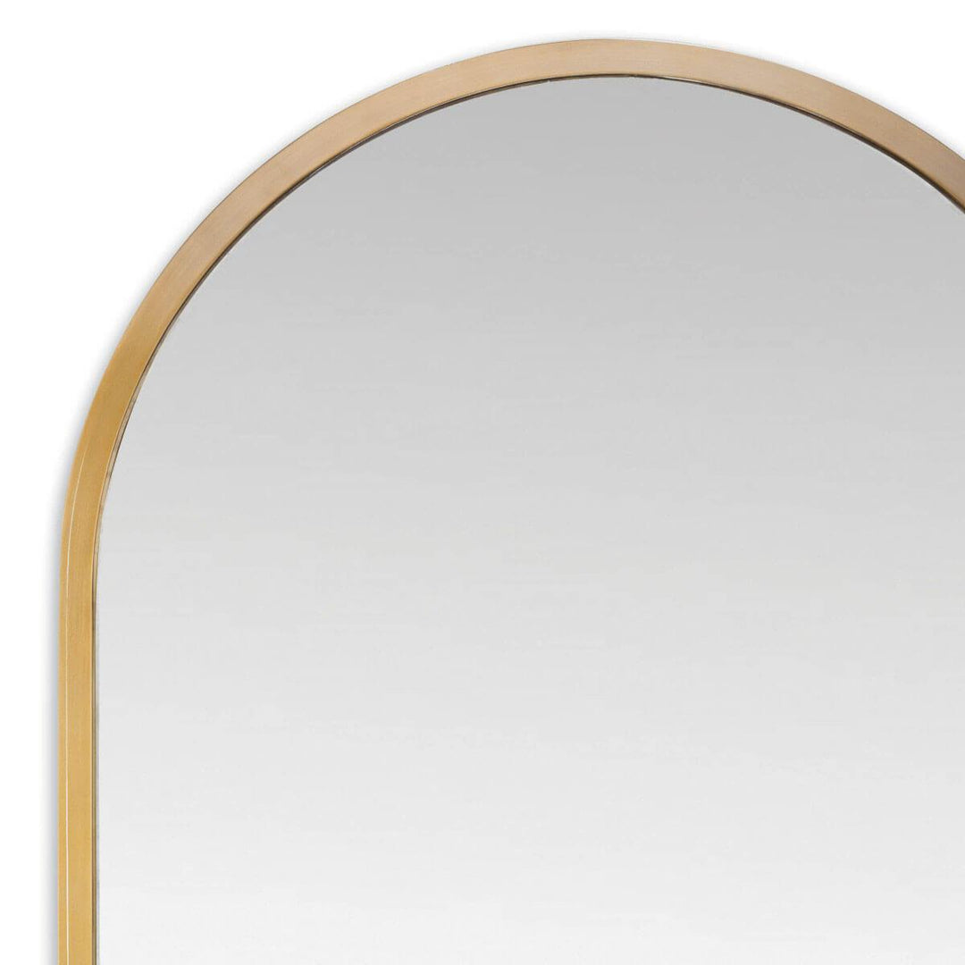 Modern rounded mirror with a stainless steel frame in a natural brass finish.