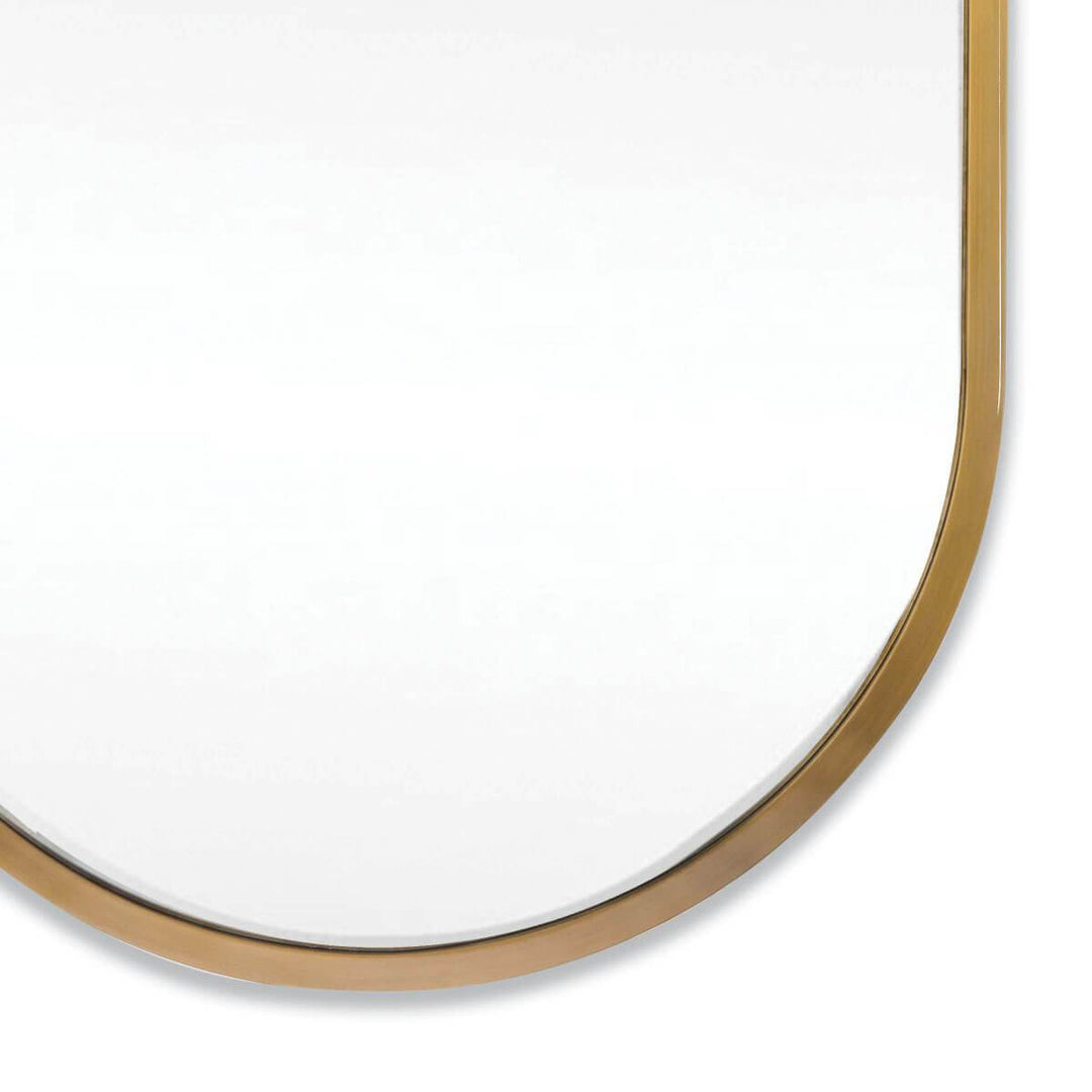 Modern oval mirror with a thin natural brass frame.