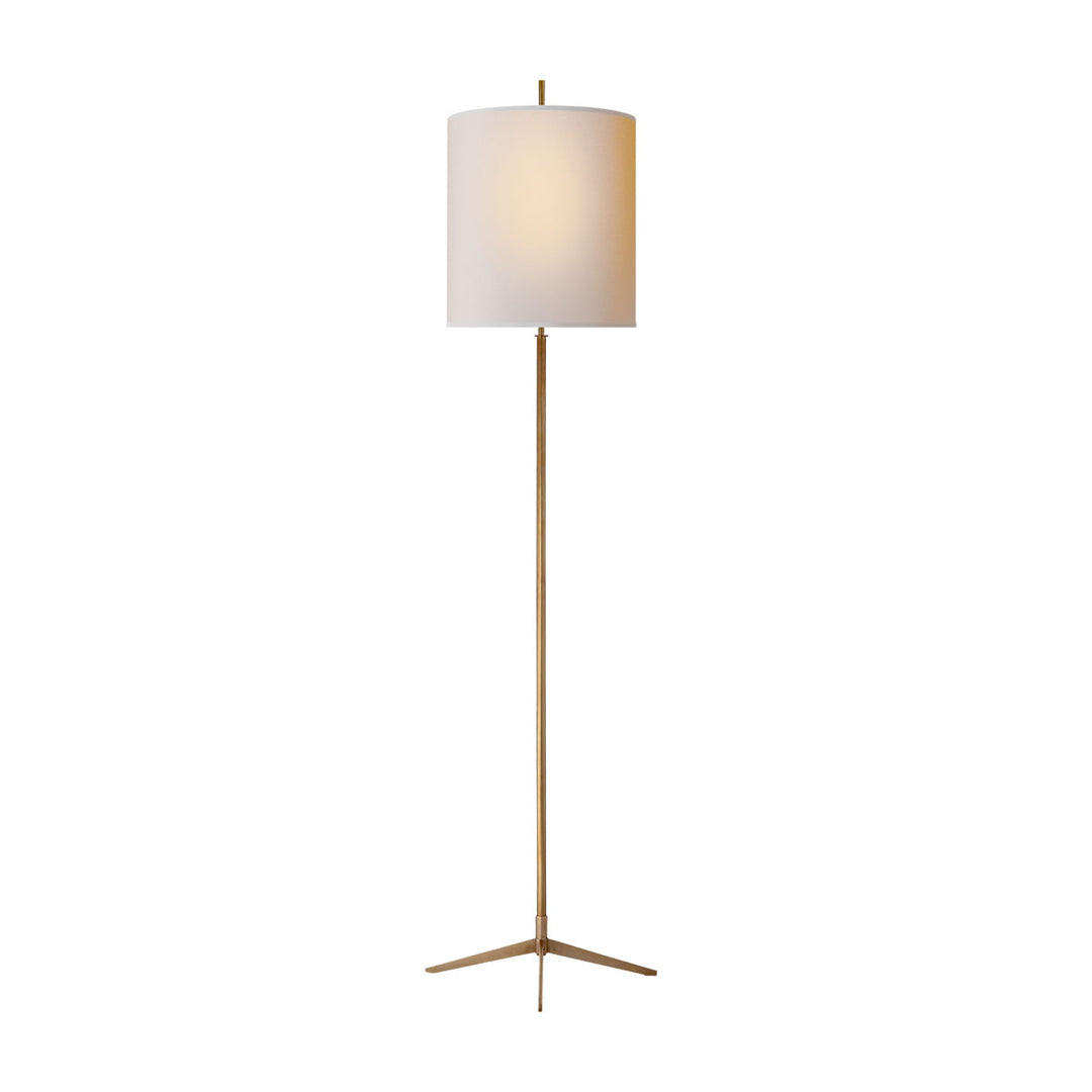 The Caron Floor Lamp has an x-shaped base in a hand-rubbed antique brass finish and a natural paper closed op shade.