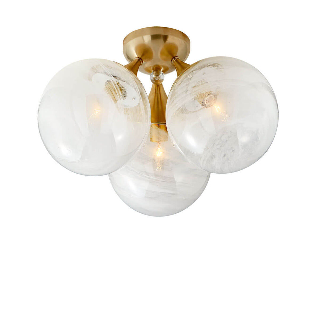 The Cristol Flush Mount has three, white strie globe glass lights with a hand-rubbed antique brass mount.