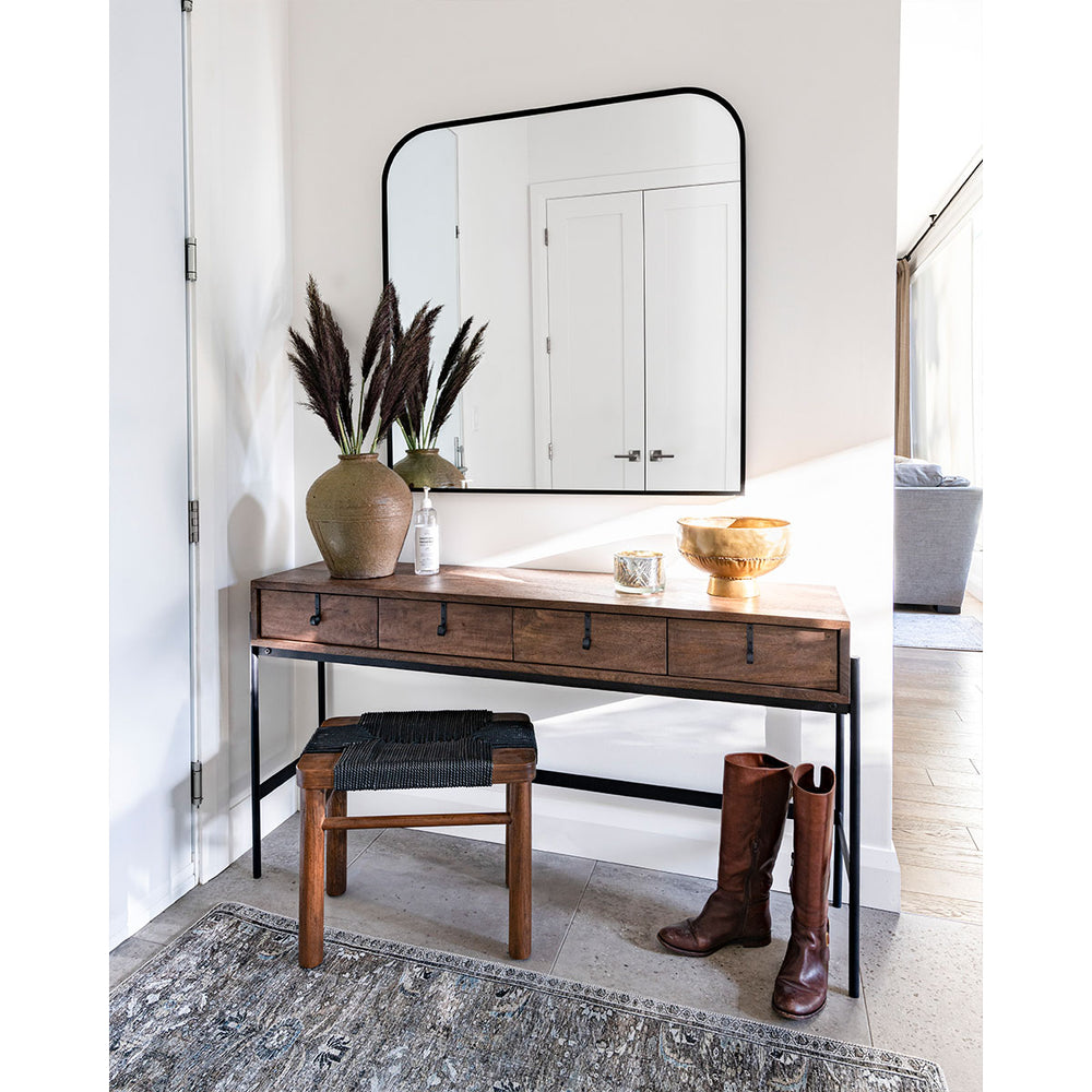 The Daphine Mirror with rounded top edges hung in a mudroom.