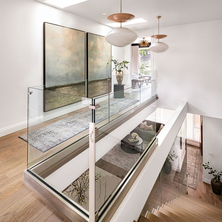 Modern and contemporary staircase with overhead skylight, large pendants art artwork.