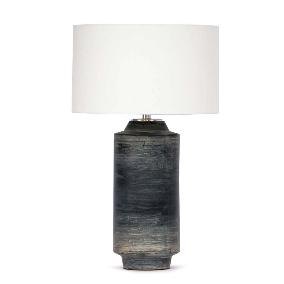 The Katla Table Lamp with a dark, textured ceramic base and complimenting natural linen drum shade.
