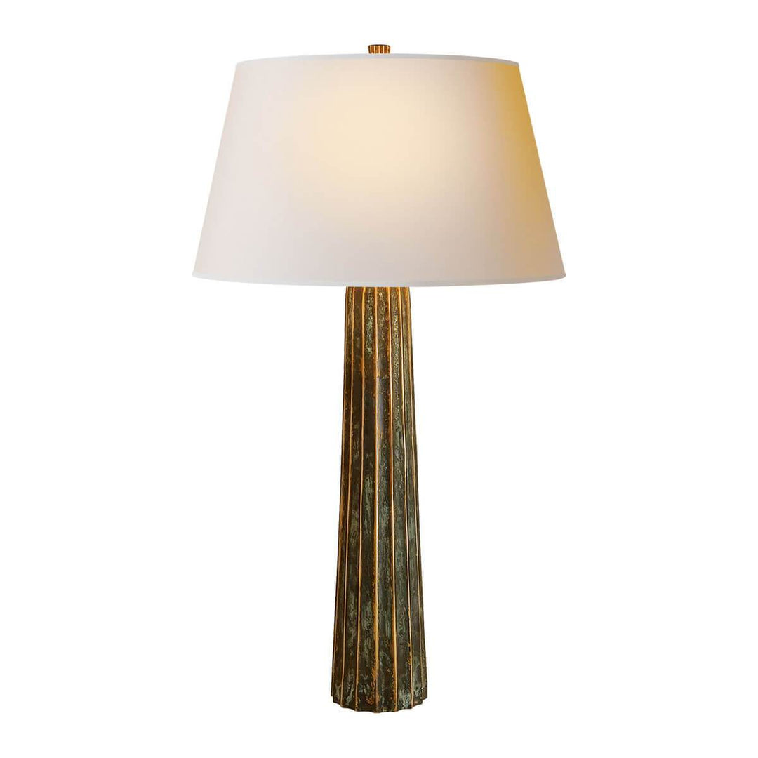 The Fluted Spire Table Lamp is a tall slim table lamp with a bronze, textured body and natural paper shade.