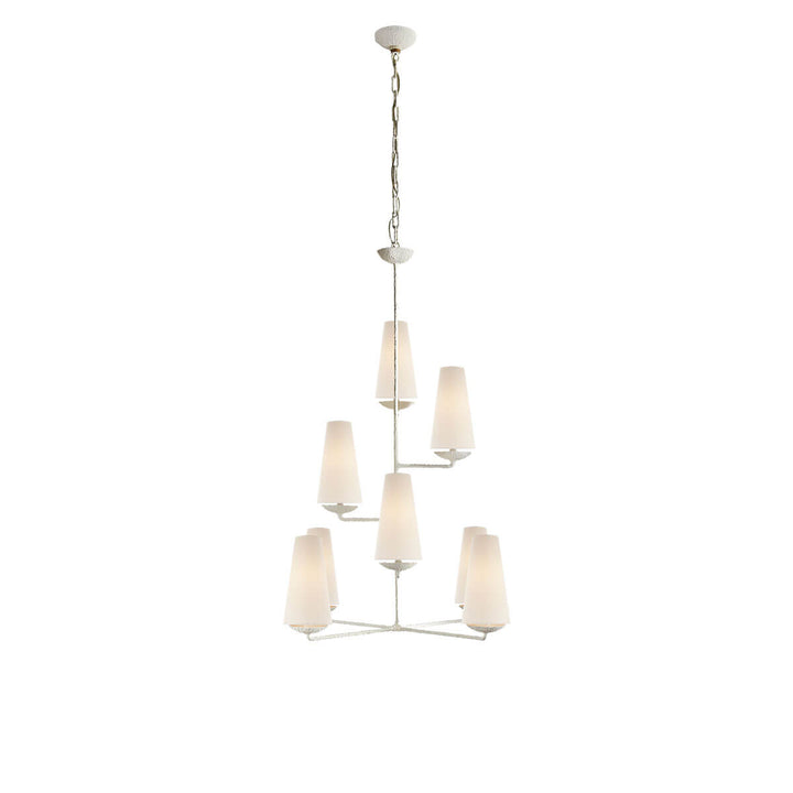 The Fontaine Vertical Chandelier is a high-ceiling chandelier with eight staggered, vertical lights with linen lamp shades and a plaster white stem.