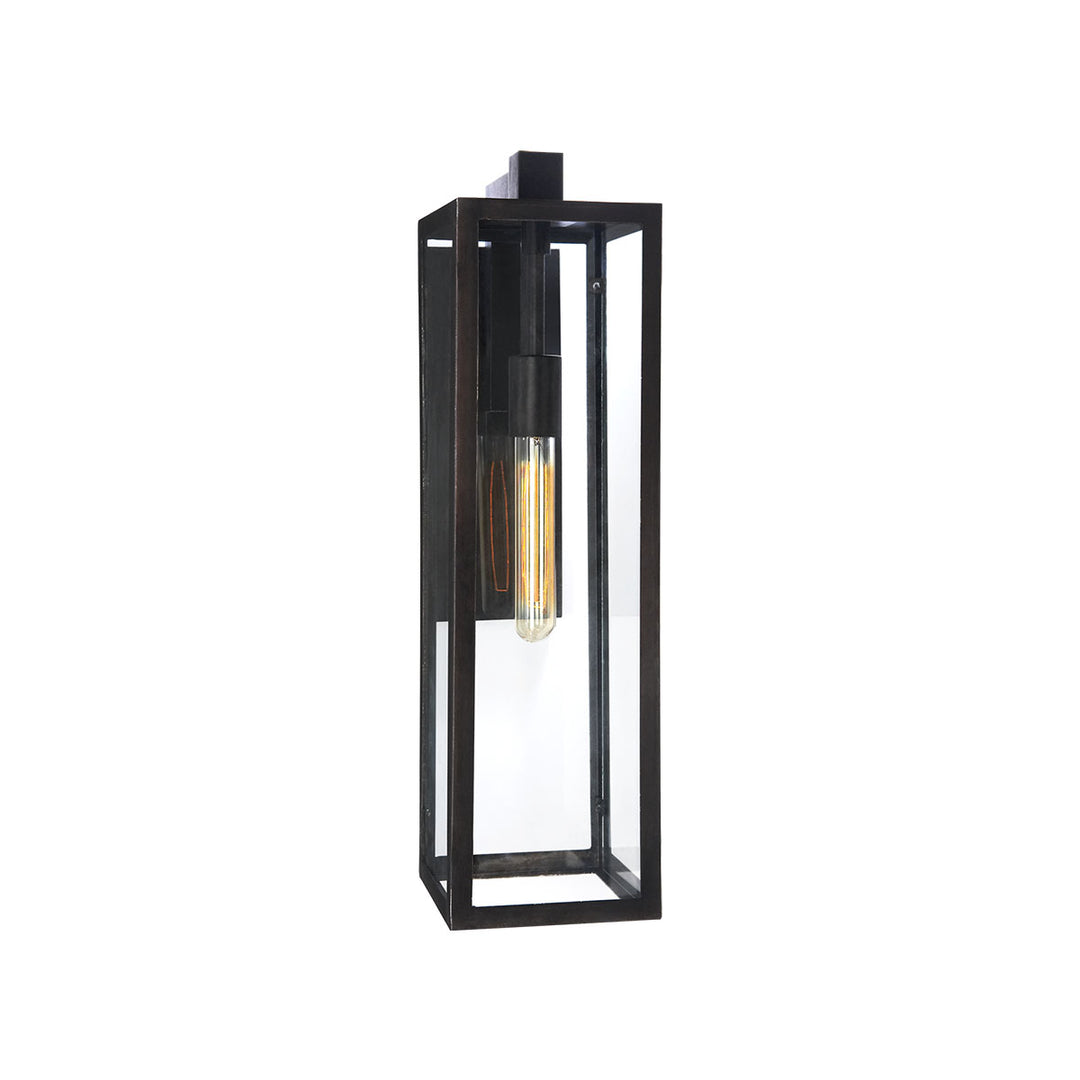The Fresno Framed Long Wall Sconce has an aged iron rectangular frame with glass panels and a thin interior lightbulb.