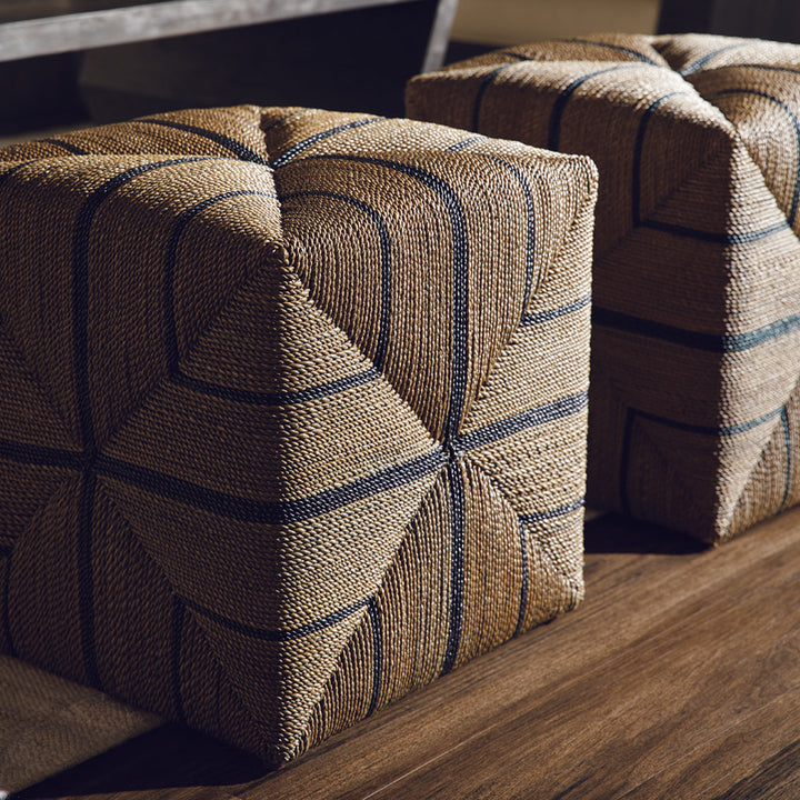 The cube shaped ottoman made from hand crafted rope in a grey with black stripe finish.