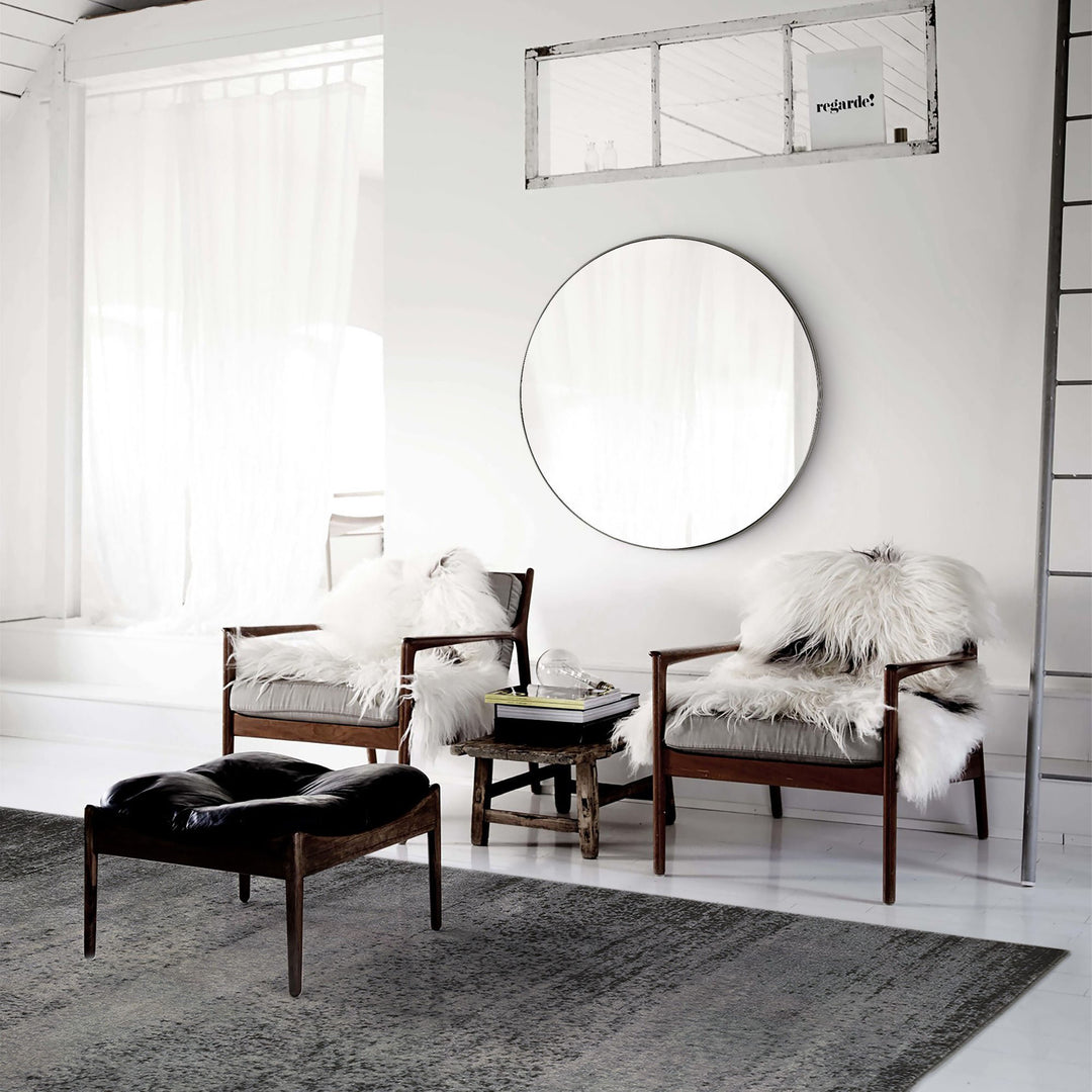 Oversized circle mirror in a living room with a modern look.