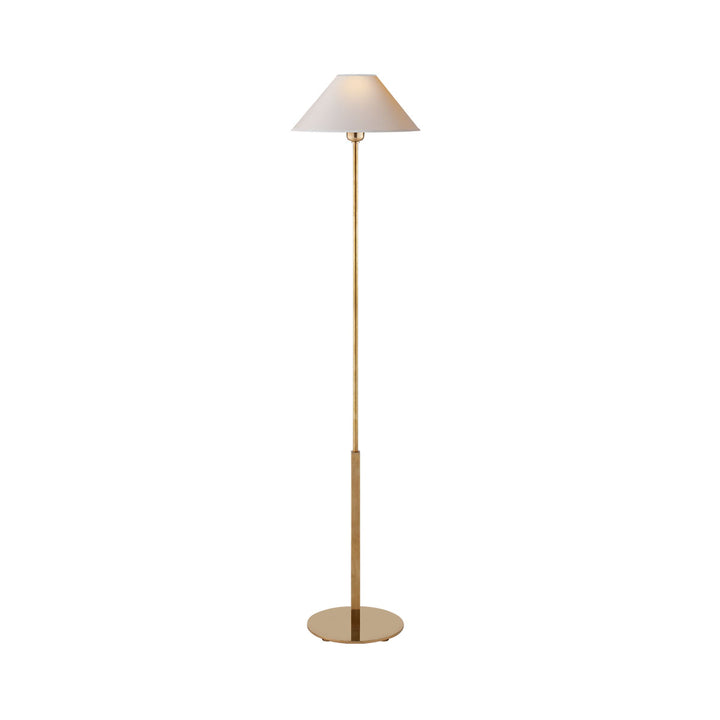 The Hackney Floor Lamp has a thin body in a hand-rubbed antique brass finish and a round, natural paper lamp shade.