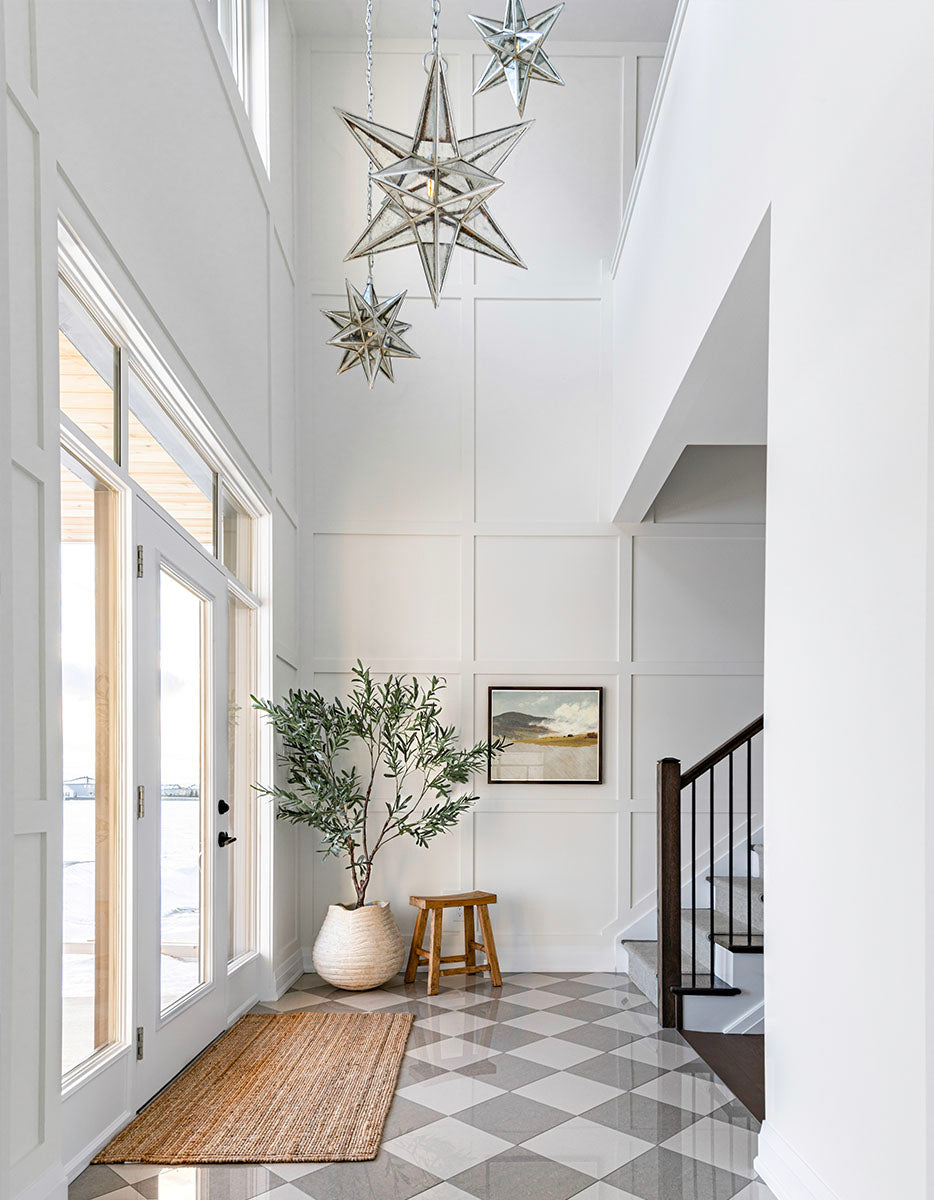 Hillside artwork in a grand entranceway with Moroccan-style lanterns. and checkered floors.