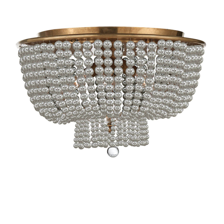 The Jacqueline Flush Mount has a hand-rubbed, antique brass canopy and a pendant with strings of clear glass beads.