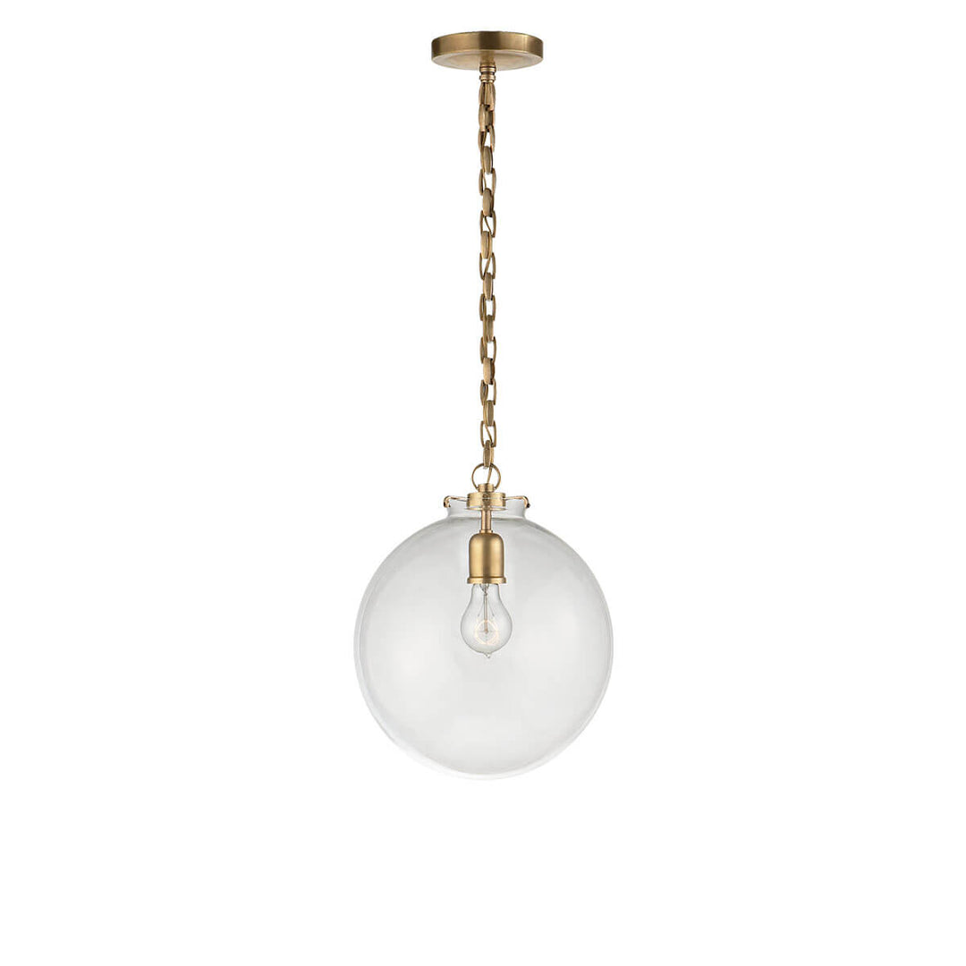 The Katie Globe Pendant is a clear glass globe ceiling light with a hand-rubbed antique brass chain and hardware.