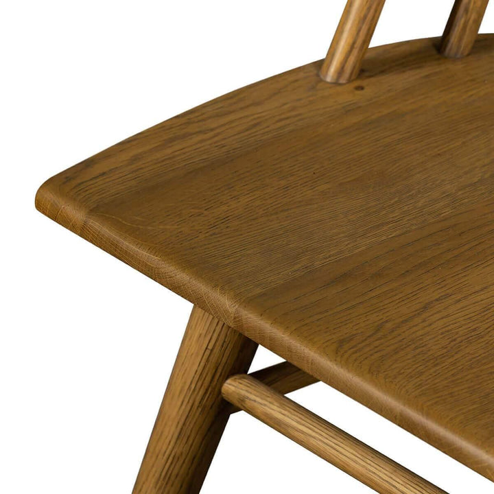 Indented seat and wood grain details on the oak dining chair.