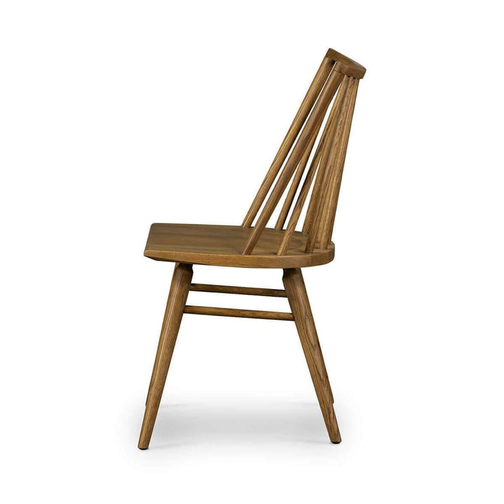 Side view of a traditional spindle back chair with tapered legs in a light oak finish.