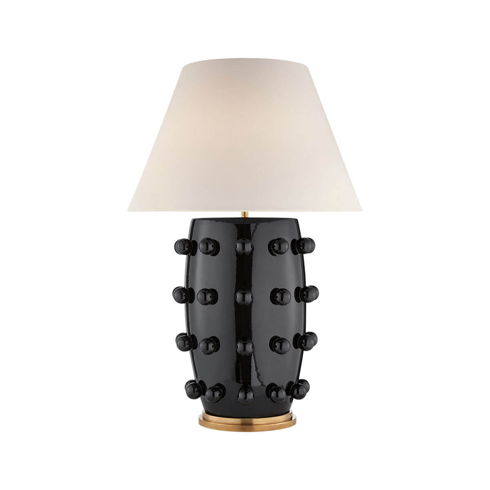 The Linden Table Lamp is a large statement lamp with a black porcelain base with ball details and an off white linen shade.