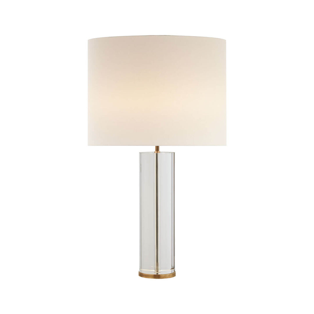 The Lineham Table Lamp has a cylindrical crystal base with brass stem running through it and a linen lamp shade.