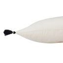 Detail of indoor lumbar pillow with black tassels on the end.