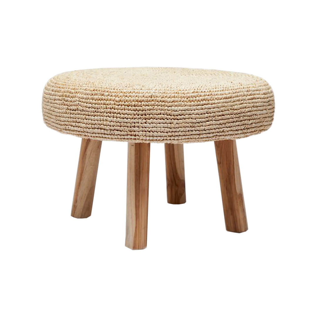 The Kailua Stool is a small stool with a round, raffia pillow top and teak legs.