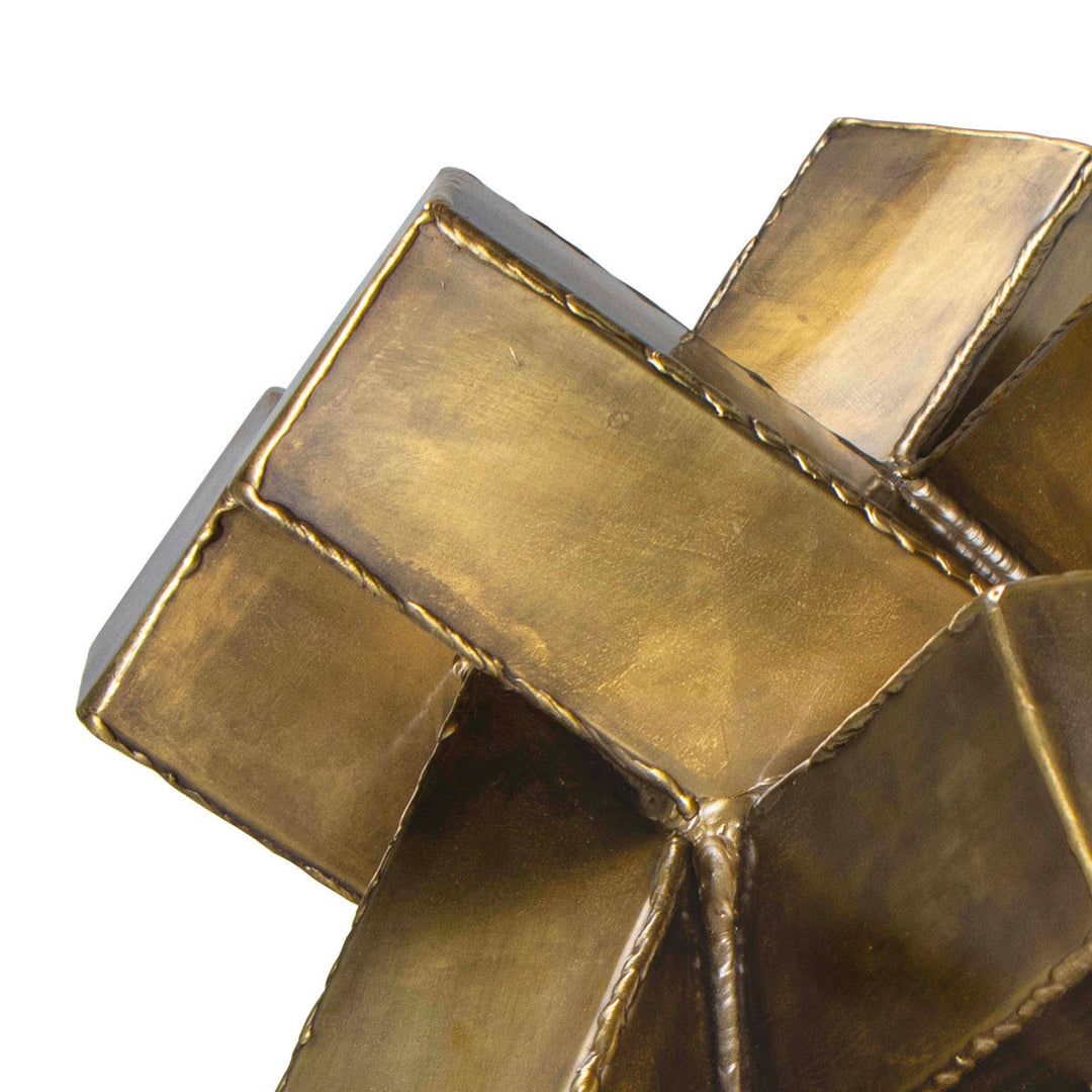 Close up image of an abstract iron metal sculpture with a brass finish.