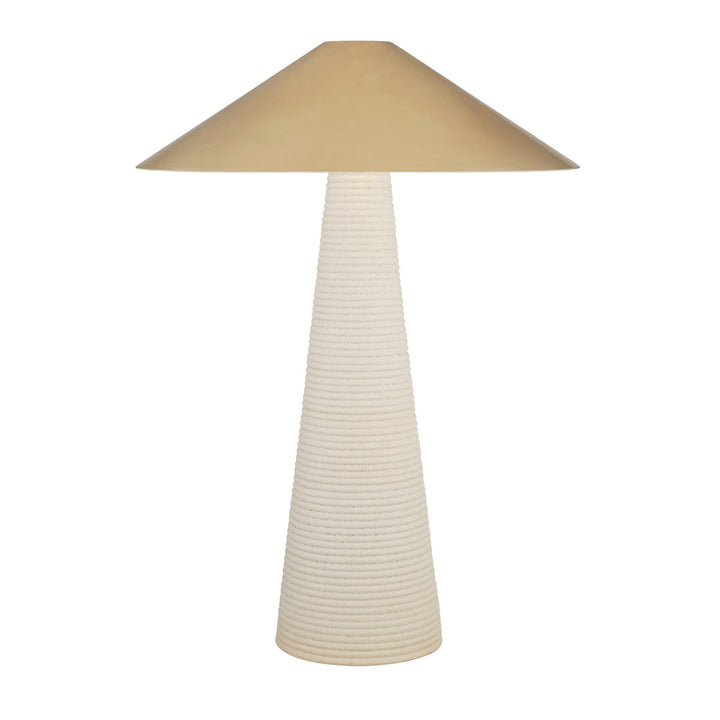 Transitional table lamp with antique brass shade and porous ceramic base.