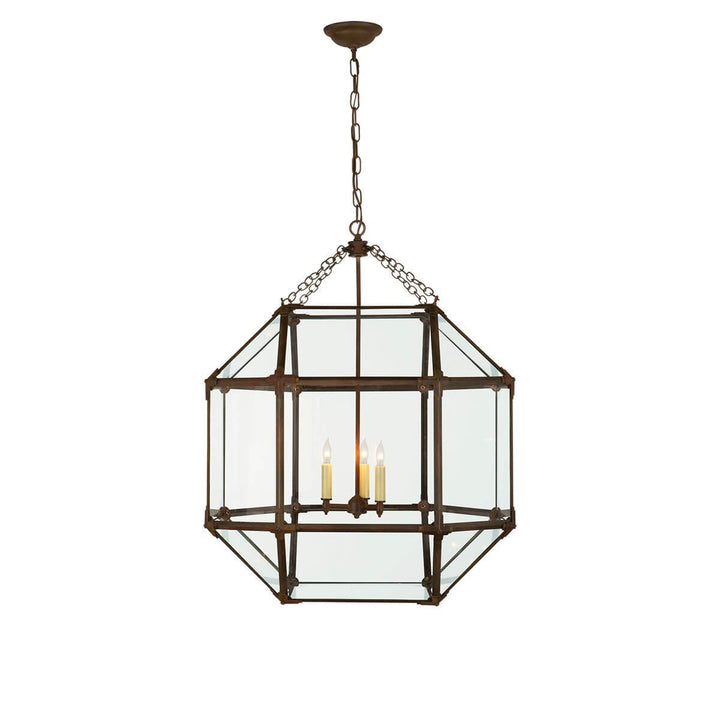 The Bruggen Large Lantern has three candelabra lights in the middle of an antique zinc cage-like frame with visible joints and clear glass panels.