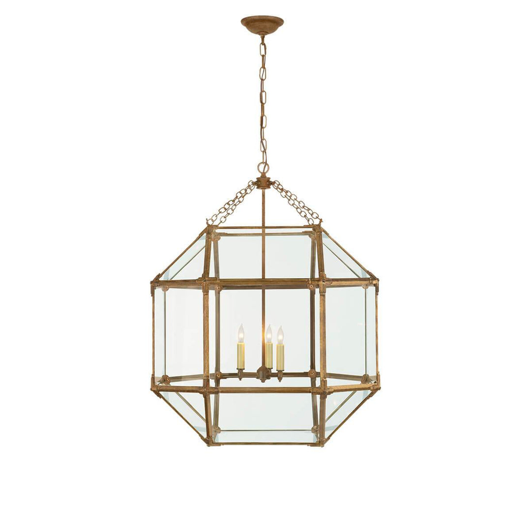 The Bruggen Large Lantern has three candelabra lights in the middle of a gilded iron cage-like frame with visible joints and clear glass panels.