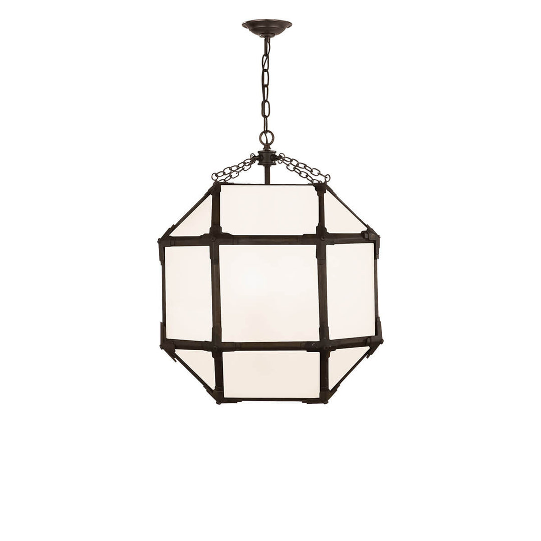 The Bruggen Medium Lantern has three candelabra lights in the middle of an antique zinc cage-like frame with visible joints and white glass panels.