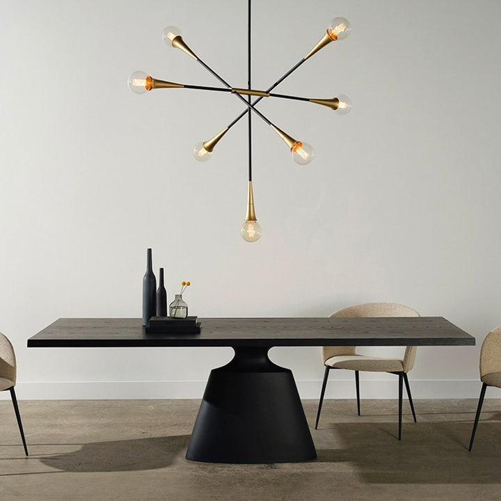 Modern dining table with a stand-alone architectural base and a floating top in a dark onyx tone. Dining table under modern chandelier.