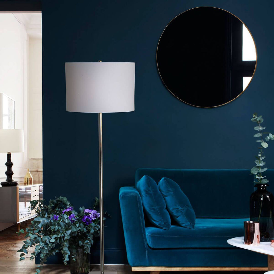 Round statement mirror in a moody, living room.