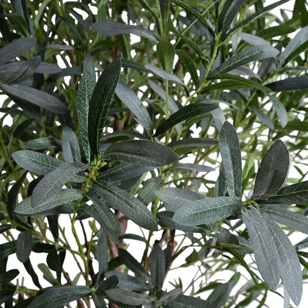 Closeup of the faux olive tree foliage and realistic artificial trunk.