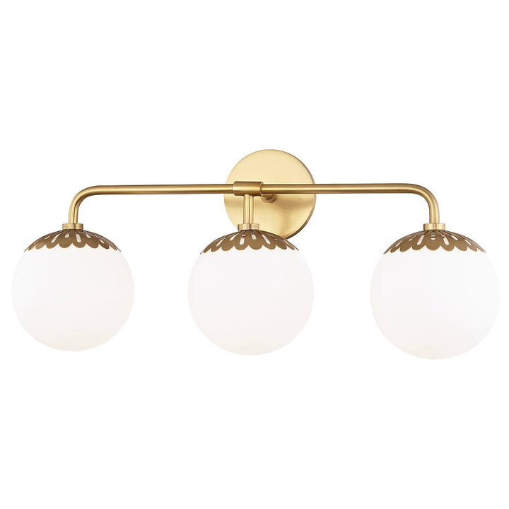 Adelaide 3 light wall sconce in an aged brass finish. White glass globe sconce in an aged brass finish, meant for a bathroom vanity.