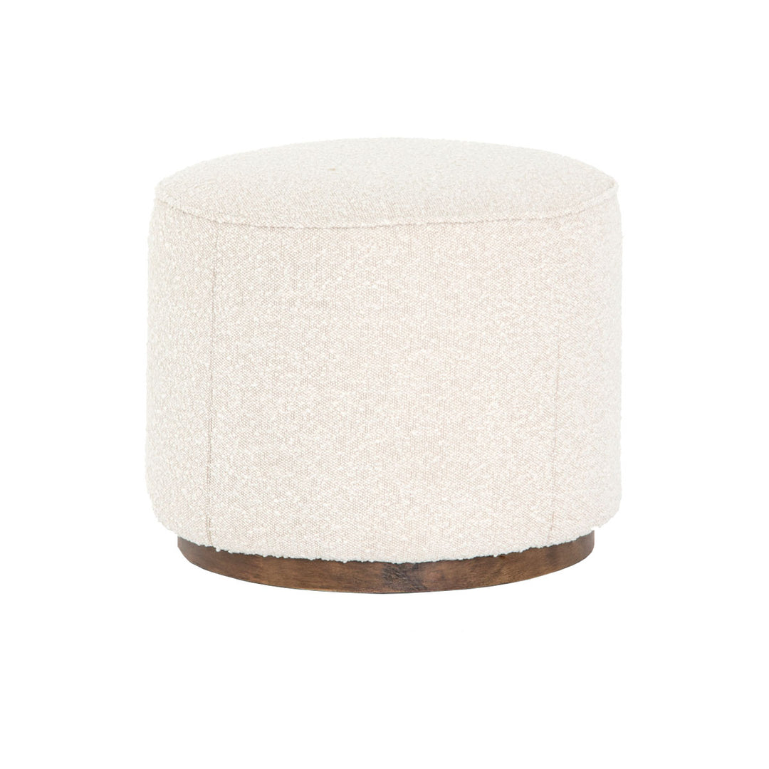 This small round ottoman, upholstered in white boucle fabric, is perfect for any living room.