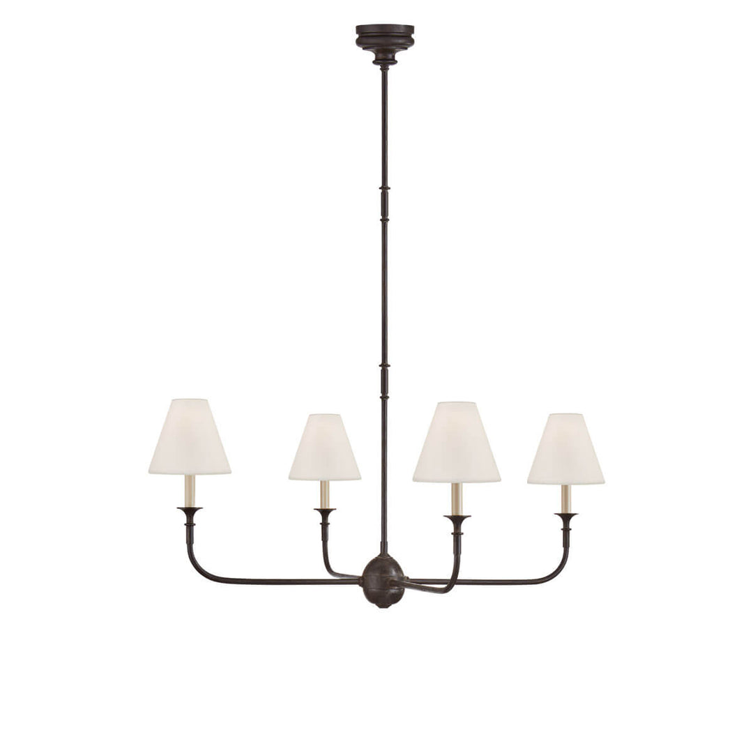 The Piaf Chandelier is a classic candelabra shaped chandelier with four small lights with linen shades and a metal frame in an aged iron finish with ebonized oak details.