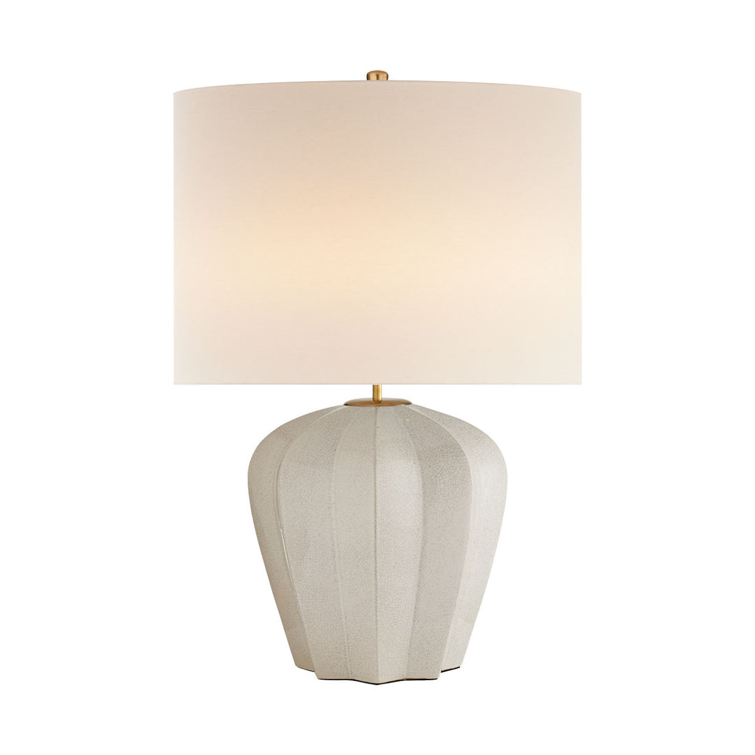 Contemporary modern table lamp with a white linen shade, glazed crackled finish on the decoratively shaped base, and warm brass details.