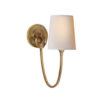 The Reed Wall Sconce has a natural paper shade and a hand-rubbed antique brass hooked arm and round backplate.