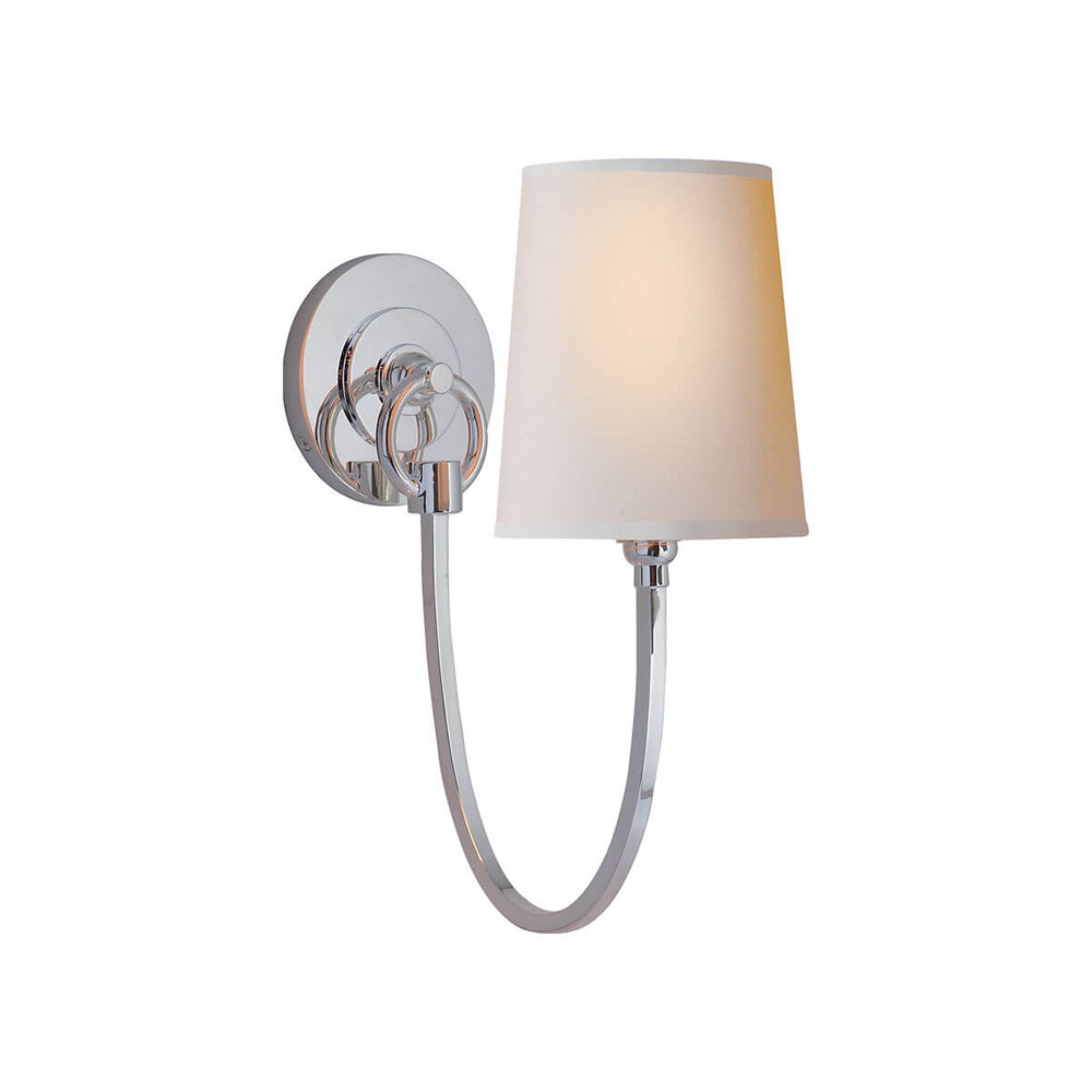 The Reed Wall Sconce has a natural paper shade and a polished silver hooked arm and round backplate.