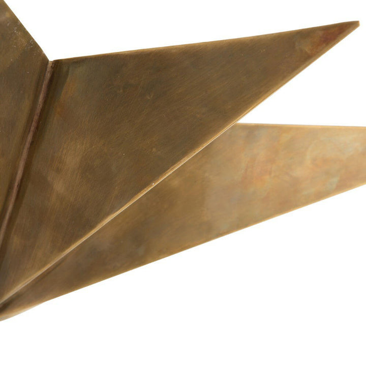 Closeup of the sculptural Tarragona Pendant with a star shape and an antique brass finish.